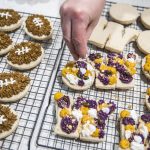 Andrea Ancich puts sprinkles on her University of Washington themed cookies. (Olivia Vanni / The Herald)