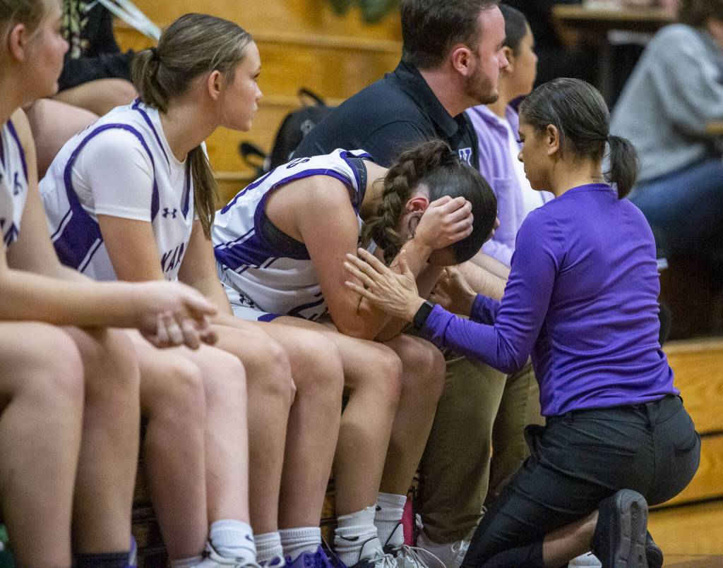 Kamiaks Finley Gonzales is comforted by her coach during the game against Lake Stevens on Wednesday, Jan. 3, 2024 in Mukilteo, Washington. (Olivia Vanni / The Herald)