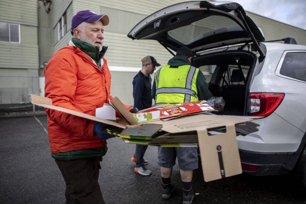 Mike Young moves cardboard during a recycling event at 1049 State Ave in Marysville, Washington on Saturday, Jan. 6, 2024. (Annie Barker / The Herald)