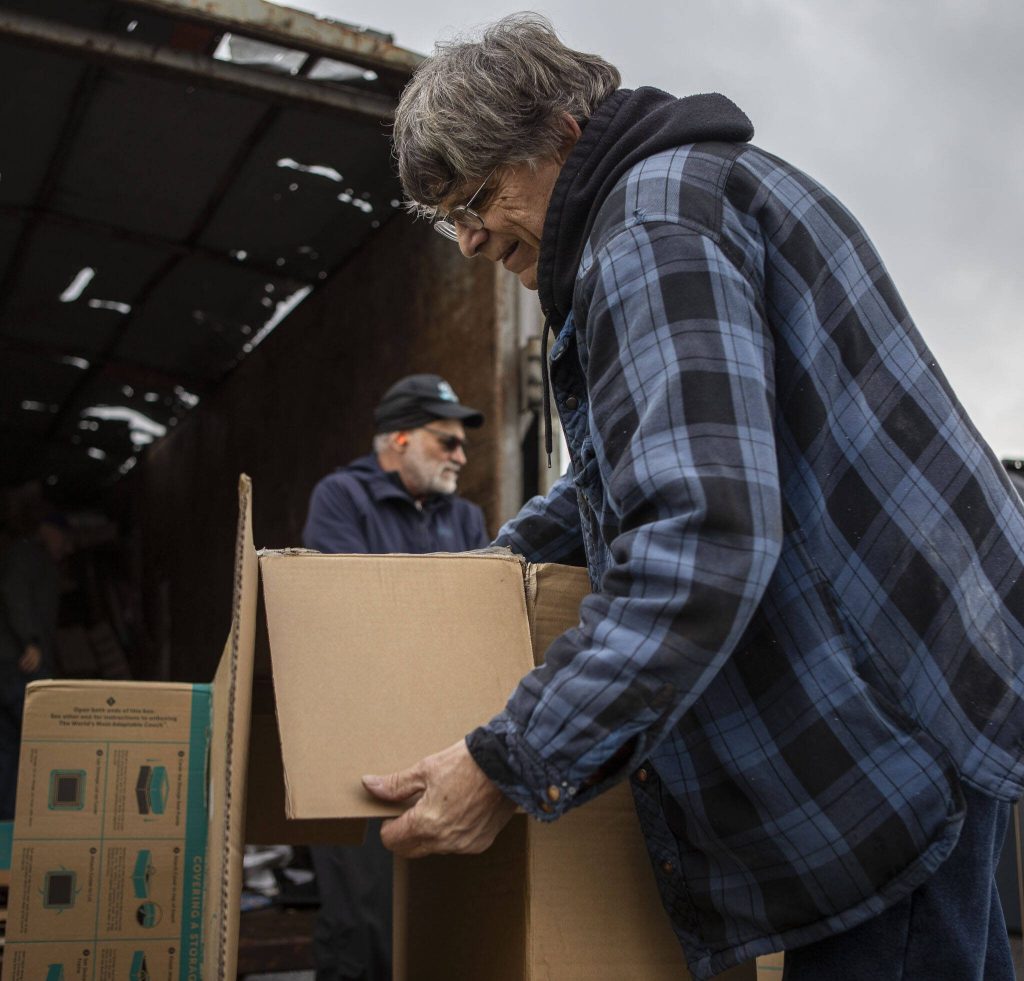 Glenn Smith breaks down a box during a recycling event at 1049 State Ave in Marysville, Washington on Saturday, Jan. 6, 2024. (Annie Barker / The Herald)