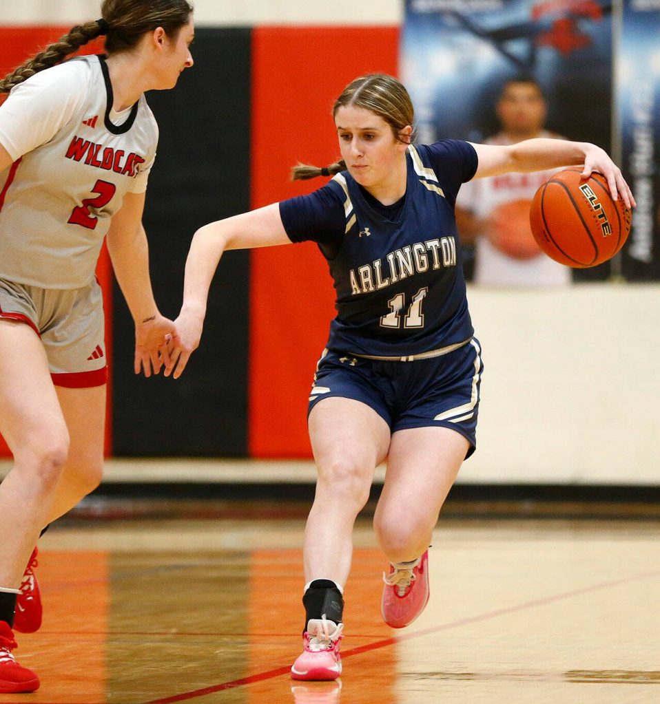 Arlingtons Addi Green goes behind the back on her way up the court against Archbishop Murphy on Tuesday, Jan. 9, 2024, at Archbishop Murphy High School in Everett, Washington. (Ryan Berry / The Herald)