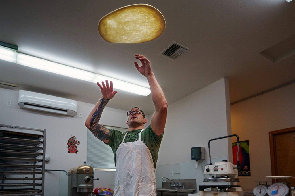 Paul Sarkis throws some pizza dough up in the air. (Photo by David Welton)