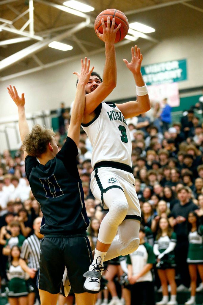 Jacksons Trey Hawkins finishes a layup at the rim against Glacier Peak on Wednesday at Henry M. Jackson High School in Mill Creek. (Ryan Berry / The Herald)