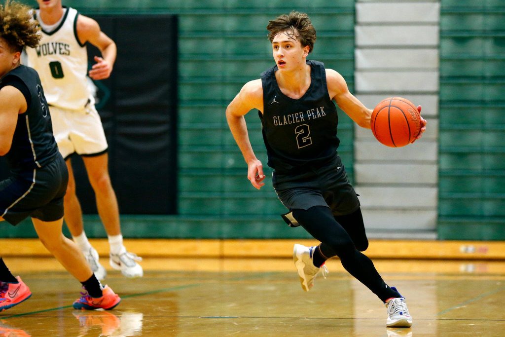 Glacier Peak junior Josiah Lee gets the ball up the court against Jackson on Wednesday, Jan. 10, 2024, at Henry M. Jackson High School in Mill Creek, Washington. (Ryan Berry / The Herald)