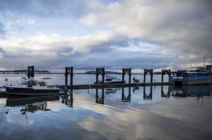 A person walks with a cart along the docks as clouds begin to roll in for an anticpated winter snowstorm at the port of Everett in Everett, Washington on Wednesday, Jan. 10, 2024.  (Annie Barker / The Herald)