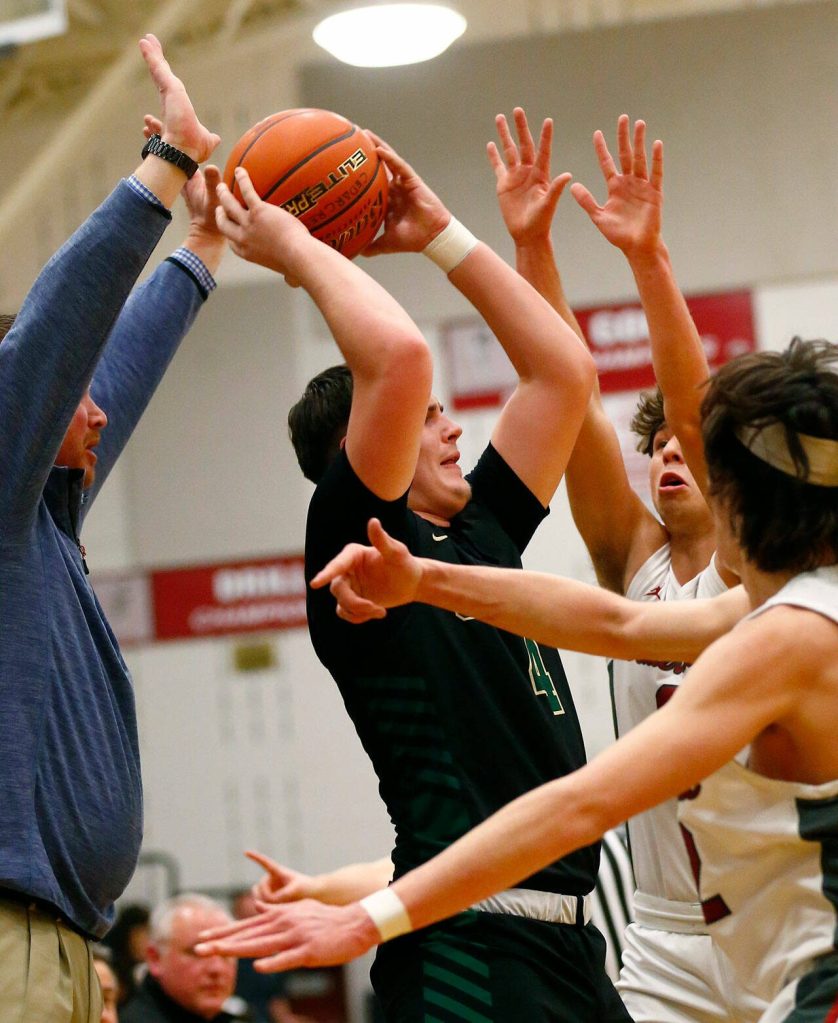 Marysville Getchells Wyatt Harris gets harassed by two defenders against Cedarcrest on Tuesday, Jan. 16, 2024, at Cedarcrest High School in Duvall, Washington. (Ryan Berry / The Herald)