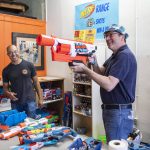 Tom Harrison laughs with a customer as they use the Nerf Range at his store on Tuesday, Sept. 6, 2022 in Everett, Washington. (Olivia Vanni / The Herald)