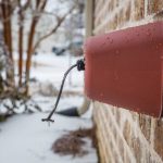 Outdoor faucet cover in the winter with icicles on it