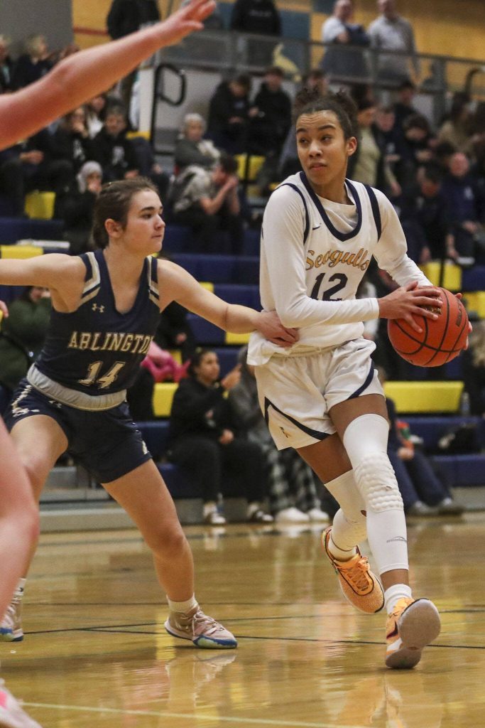 Everetts Alana Washington (12) moves with the ball during a girls basketball game between Arlington and Everett at Everett High School on Friday. (Annie Barker / The Herald)