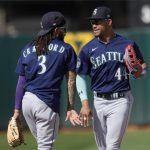 Seattle Mariners' J.P. Crawford (3) celebrates with Julio Rodriguez (44) after the Mariners defeated the Oakland Athletics in a baseball game in Oakland, Calif., Wednesday, Sept. 20, 2023. (AP Photo/Jeff Chiu)