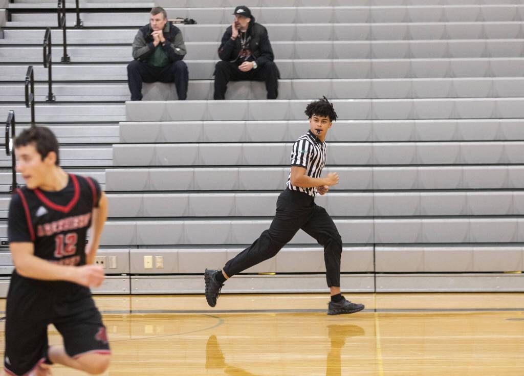 Chandler Hyde runs down a court while refereeing a game Jan. 16 at Lynnwood High School in Bothell. (Olivia Vanni / The Herald)