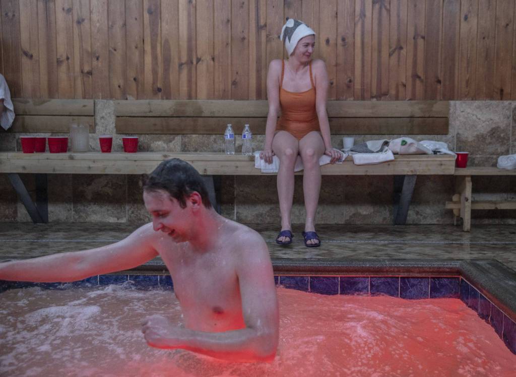 Alex S., left, and Kate S., right, hang out in a pool area after getting out of the hot sauna at Banya in Everett. (Olivia Vanni / The Herald)