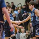Toby Trichler, left, and brother Eli Trichler, right, high-five after a blocked shot during the game against Kings on Jan. 23 in Shoreline. (Olivia Vanni / The Herald)