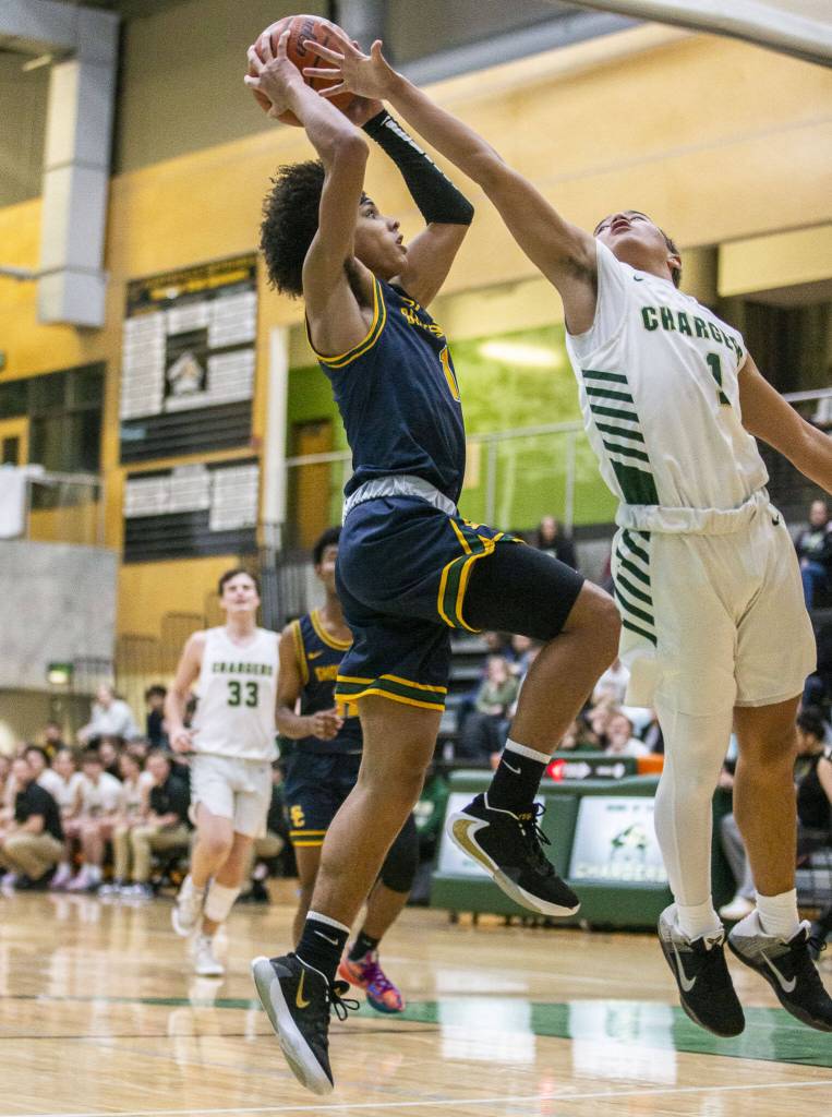 Marysville Getchells Ano Palacol, left, attempts to block a shot against Shorecrest during the game on Dec. 16, 2022, in Marysville. (Olivia Vanni / The Herald)