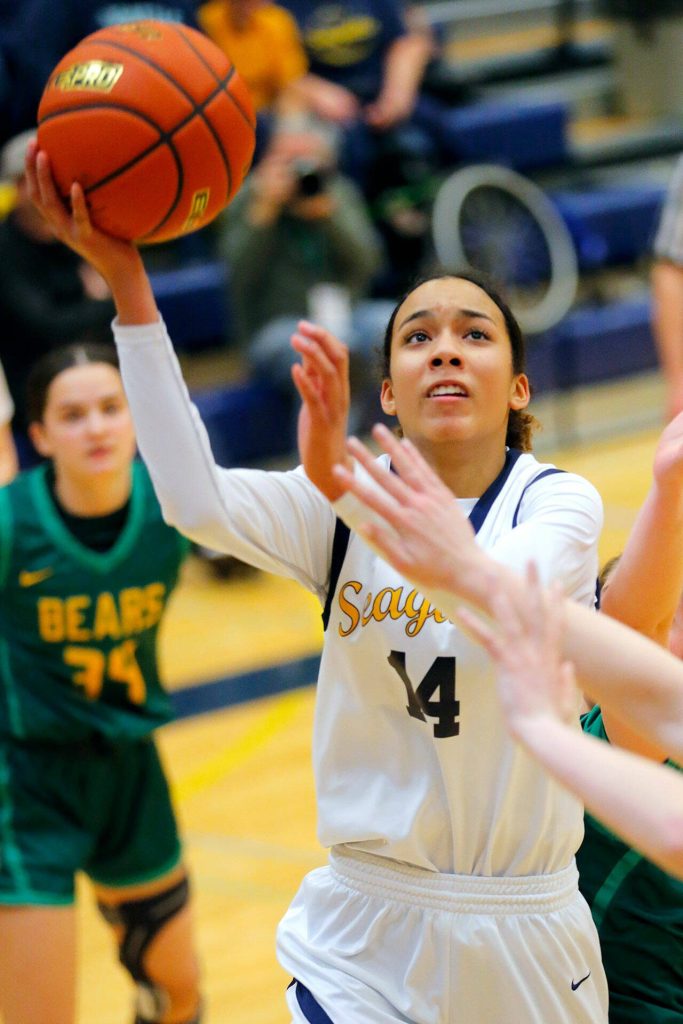 Everetts Mae Washington lays in a contested shot against during a state regionals game on Feb. 21, 2023, in Everett. (Ryan Berry / The Herald)