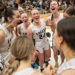 Arlington twins Rachel Snow (center left) and Katie Snow (24) yell in celebration with teammates after winning the Class 3A District 1 championship Feb. 18, 2023 in Everett. (Olivia Vanni / The Herald)