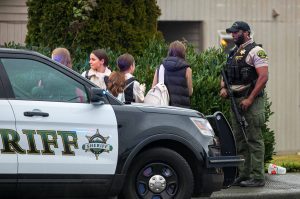A Snohomish County sheriff’s deputy speaks to a group of young girls trying to go home from school during a police standoff Wednesday, Jan. 31, 2024, in south Everett, Washington. (Ryan Berry / The Herald)