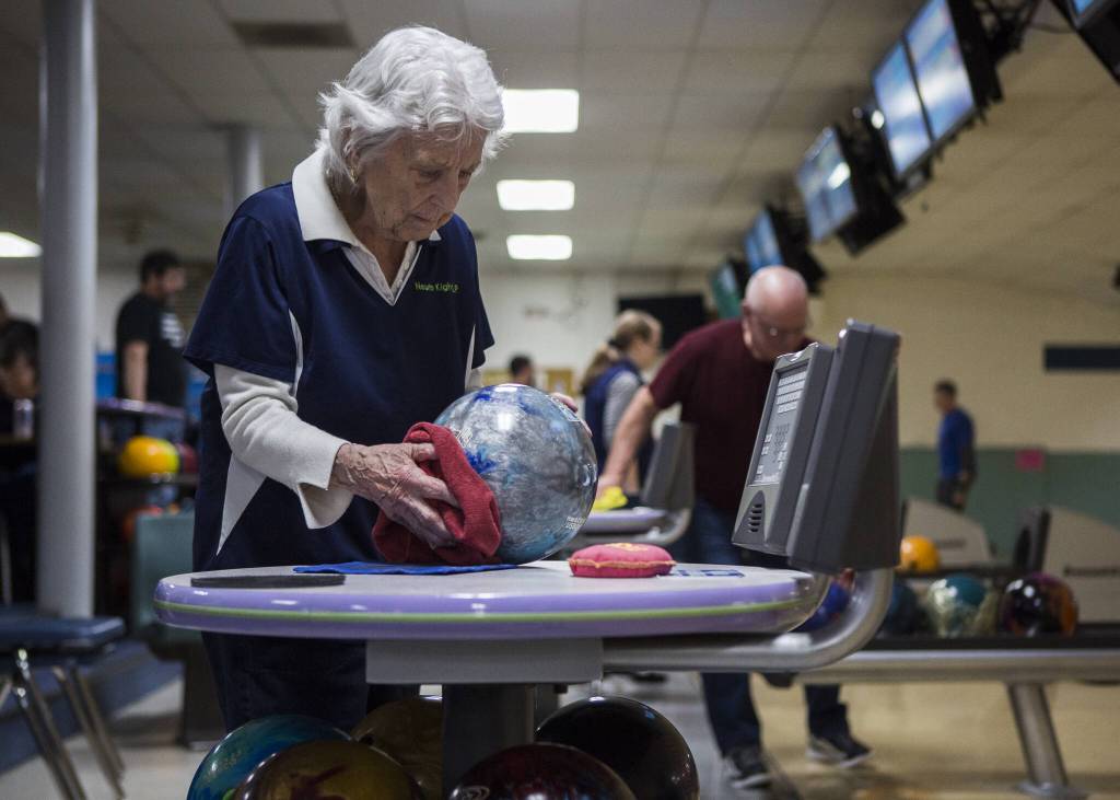 Carol Perry, 101, wipes her bowling ball before her turn to bowl during league bowling at Strawberry Lanes on Wednesday, Feb. 26, 2020 in Marysville , Wa. (Olivia Vanni / The Herald)