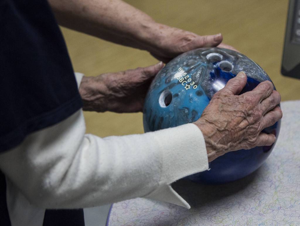 Carol Perry holds her ball as she waits for her turn during league bowling at Strawberry Lanes on Wednesday, Feb. 26, 2020 in Marysville , Wa. (Olivia Vanni / The Herald)
