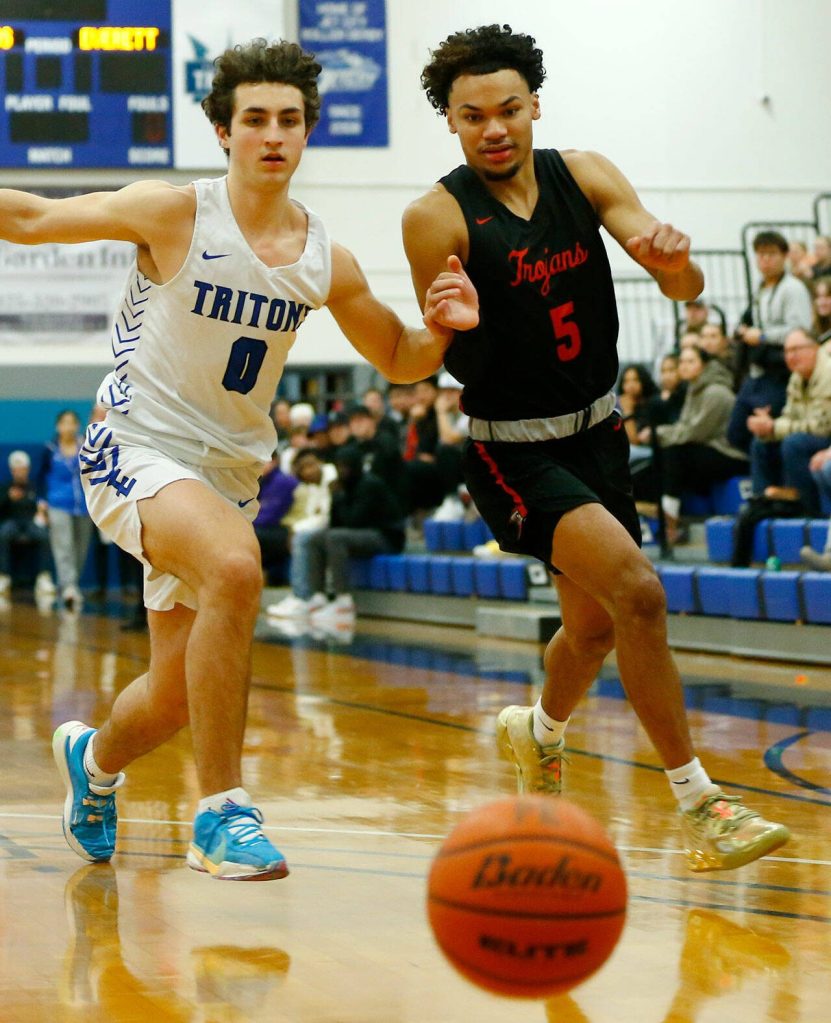 Edmonds Colleges Jack Sims and Everett Community Colleges Daniel Headdings both chase after a loose ball during a matchup between their teams on Wednesday, Feb. 7, 2024, at Seaview Gym in Lynnwood, Washington. (Ryan Berry / The Herald)