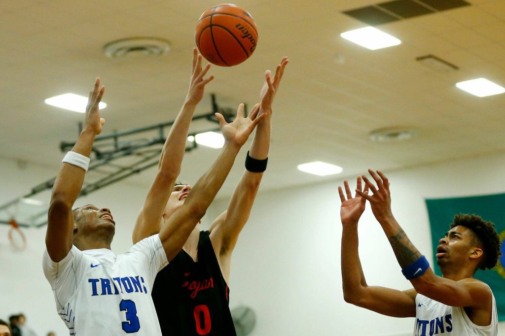 Edmonds College and Everett Community College players all reach for a rebound on Wednesday, Feb. 7, 2024, at Seaview Gym in Lynnwood, Washington. (Ryan Berry / The Herald)