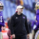 Former Washington offensive coordinator Ryan Grubb, center, talks with quarterback Dylan Morris (5) and quarterback Michael Penix Jr. (9) as they warm up before a game Nov. 25, 2023, in Seattle. Grubb is expected to be the next offensive coordinator of the Seattle Seahawks. (AP Photo/Lindsey Wasson)