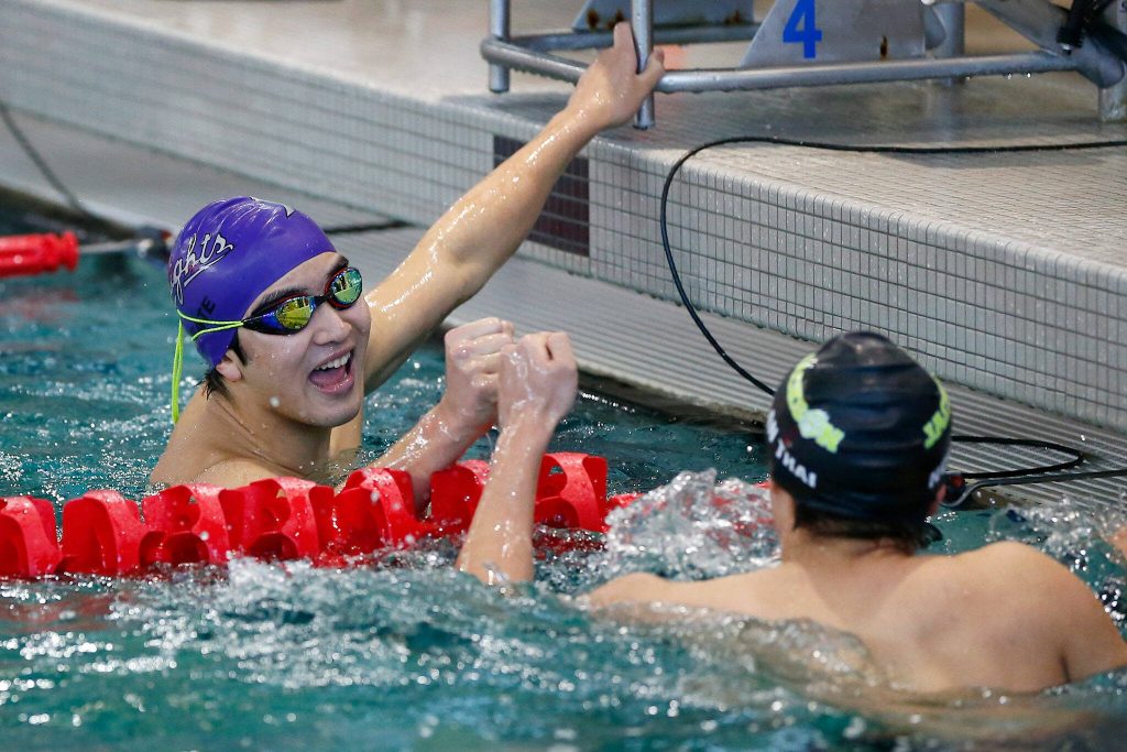 Kamiaks Bryan Zi Wong congratulates Jackson freshman Nolan Thai at the end of the 500-yard freestyle during the Class 4A District 1 swim and dive championships Saturday at the Snohomish Aquatic Center in Snohomish. (Ryan Berry / The Herald)