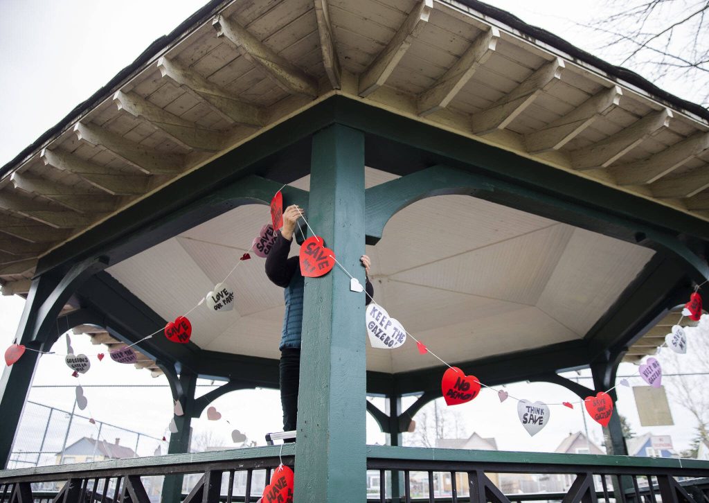 People hang up hearts with messages about saving the Clark Park gazebo during a heart bomb event hosted by Historic Everett on Saturday, Feb. 17, 2024 in Everett, Washington. (Olivia Vanni / The Herald)