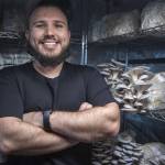 Nathanael Engen poses for a photo with mushrooms he grows at his property in Everett, Washington on Monday, March 27, 2023. Engen describes his business as cultivating mushrooms, and healthy communities. (Annie Barker / The Herald)