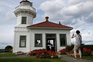 A couple takes a photo in front of the Mukilteo Lighthouse. The lighthouse, built in 1906, is one of the most iconic landmarks in all of Snohomish County. (Olivia Vanni / The Herald)