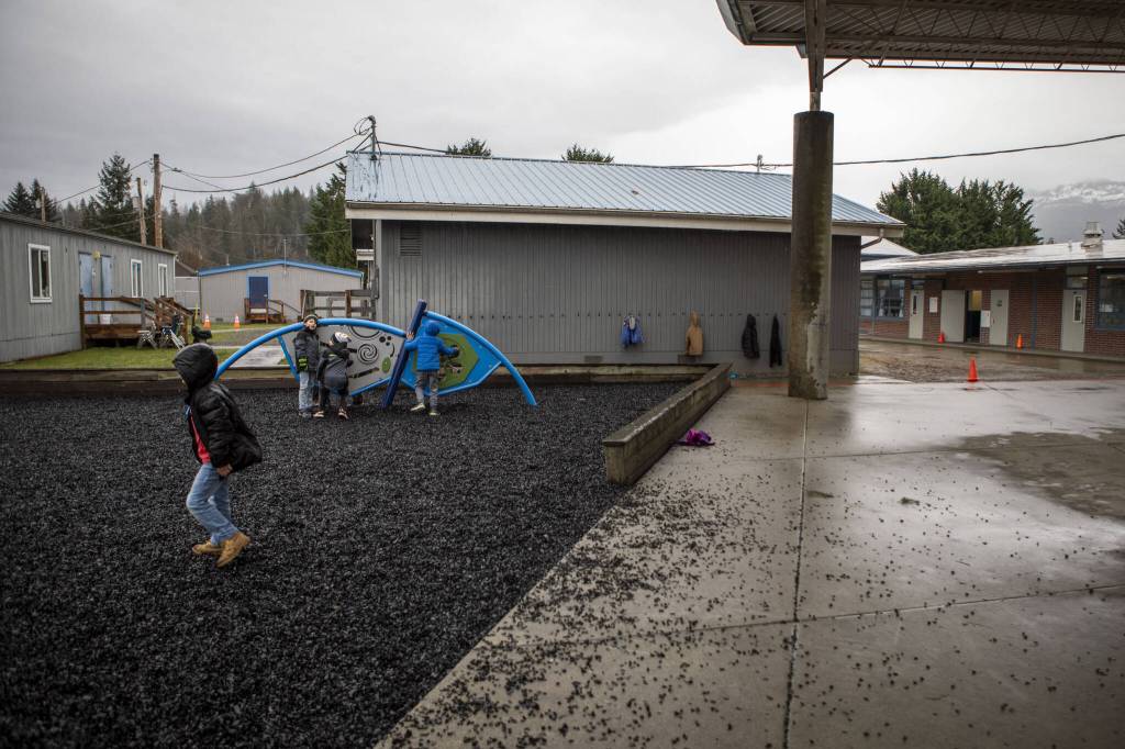 Children play next to the main school building and portable classrooms at the Sultan Elementary School on Wednesday, Jan. 24, 2024 in Sultan, Washington. (Annie Barker / The Herald)