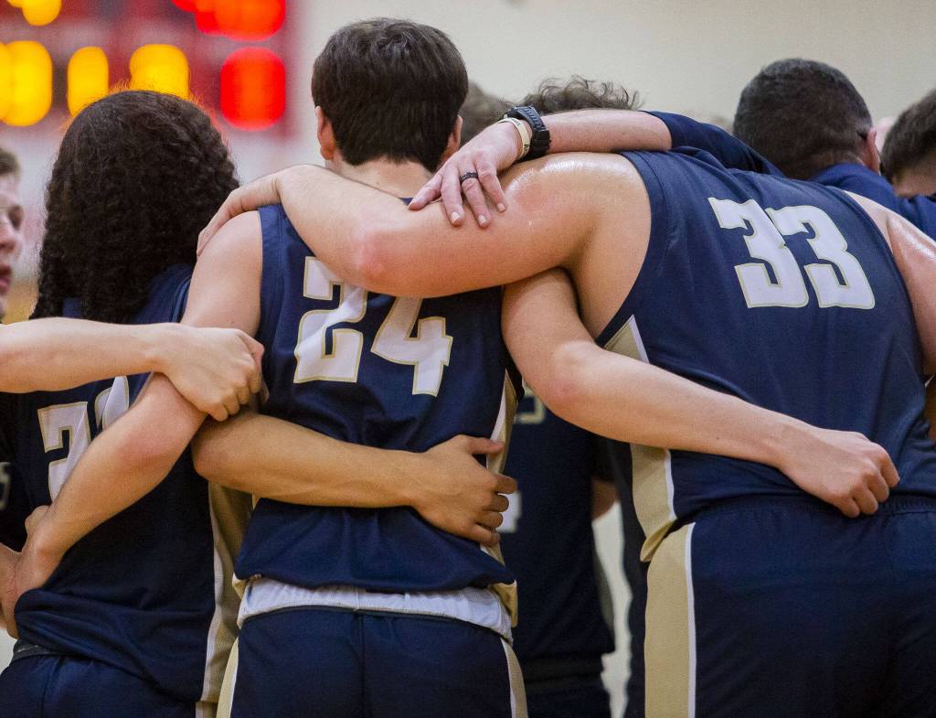 Arlington players huddle during a timeout during the game against Mount Vernon on Tuesday, Feb. 13, 2024 in Marysville, Washington. (Olivia Vanni / The Herald)