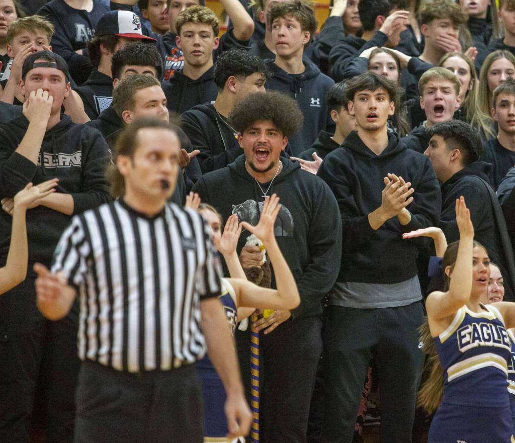 Arlington fans yell at the referee during the game against Mount Vernon on Tuesday, Feb. 13, 2024 in Marysville, Washington. (Olivia Vanni / The Herald)