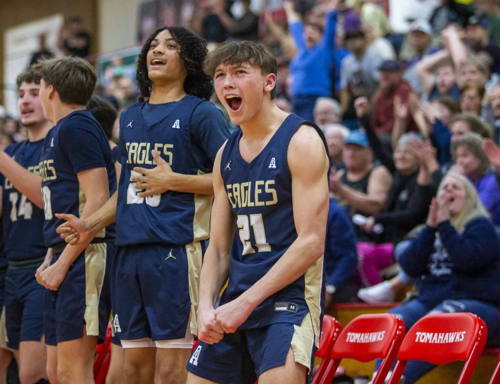 The Arlington bench reacts to a three point shot during the game against Mount Vernon on Tuesday, Feb. 13, 2024 in Marysville, Washington. (Olivia Vanni / The Herald)