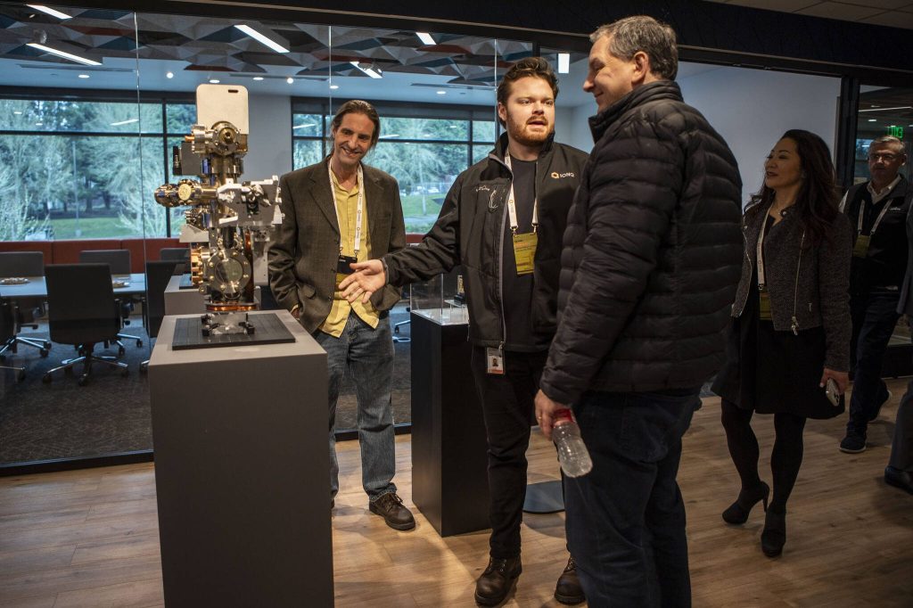 People mingle during an IonQ ribbon cutting event at their research and manufacturing facility on Thursday, Feb. 15, 2024 in Bothell, Washington. (Annie Barker / The Herald)