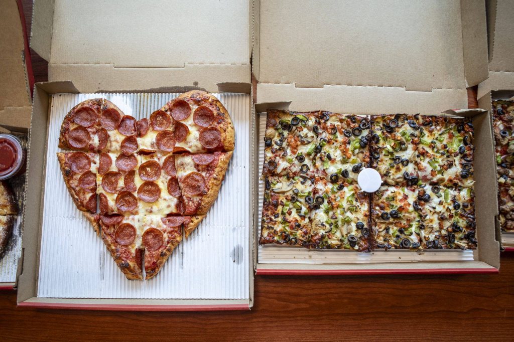 A heart-shaped, hand-tossed pepperoni pizza, left, and an 8 Corner Detroit-style Veggie pie from Jets Pizza in Lynnwood. (Annie Barker / The Herald)