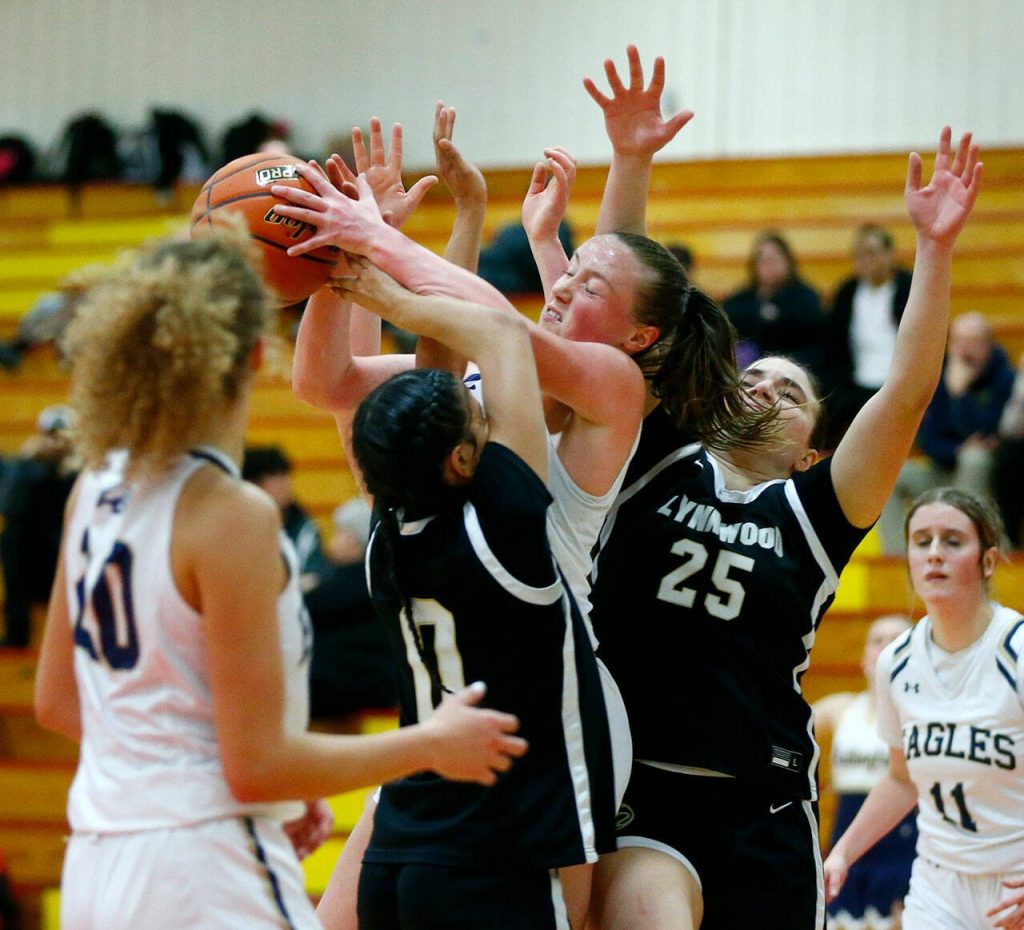 Arlingtons Katie Snow pulls down a rebound in traffic against Lynnwood during the 3A District 1 semifinals on Wednesday at Marysville Pilchuck High School in Marysville. (Ryan Berry / The Herald)