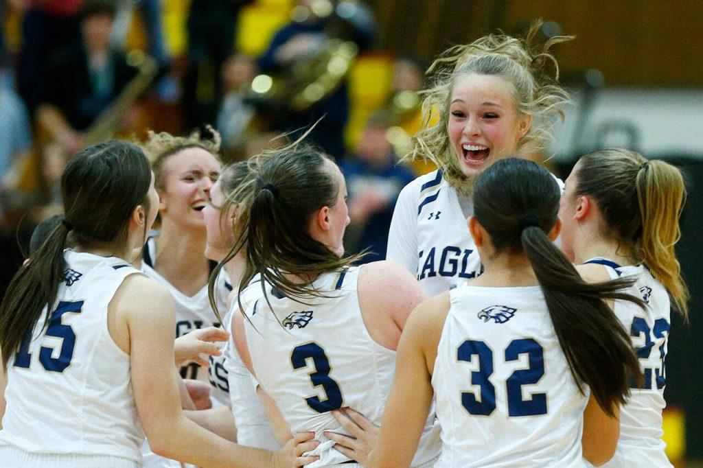 The Arlington girls celebrate a close victory over Lynnwood during the 3A District One Semifinals on Wednesday, Feb. 14, 2024, at Marysville Pilchuck High School in Marysville, Washington. (Ryan Berry / The Herald)