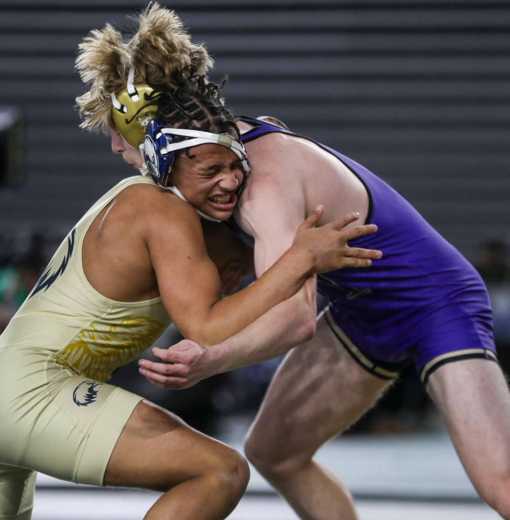 Arlington’s Tre Haines and Oak Harbors Percie Hatfield wrestle during the 3A boys 157-pound championship match during Mat Classic XXXV on Saturday, Feb. 17, 2024, at the Tacoma Dome in Tacoma. (Annie Barker / The Herald)