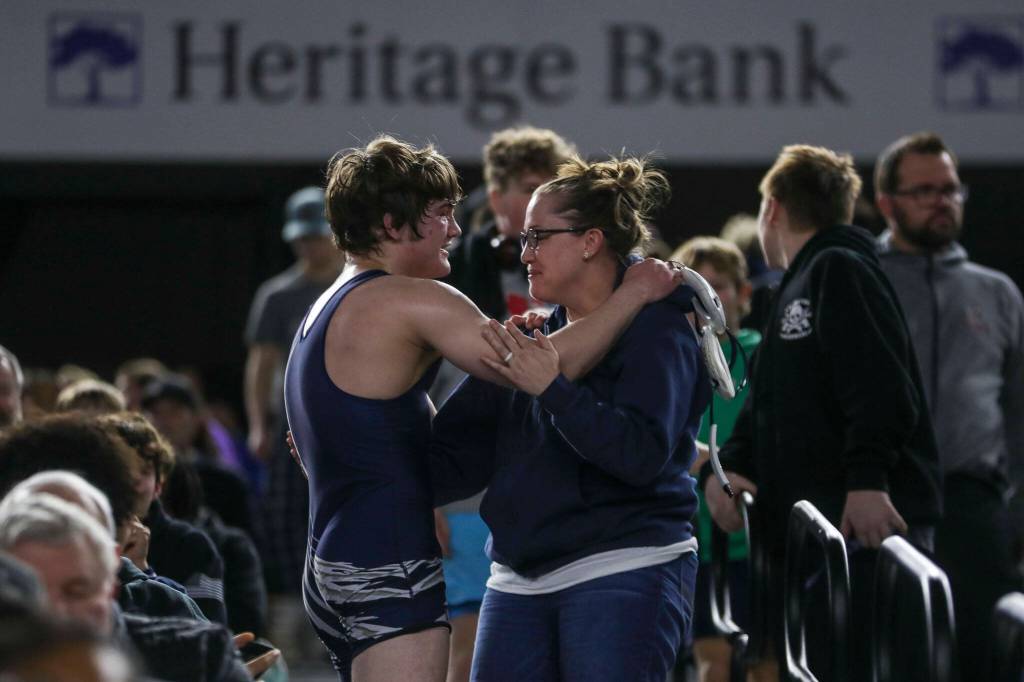 Glacier Peak’s Gil Mossburg hugs his mom after winning the 4A boys 150-pound championship match during Mat Classic XXXV on Saturday, Feb. 17, 2024, at the Tacoma Dome in Tacoma. (Annie Barker / The Herald)
