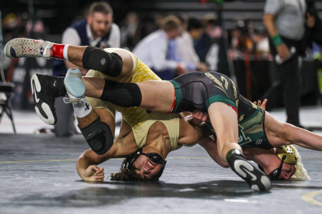 Arlington’s Dayton Fitzgibbon and Auburns Bryce Rowland wrestle during the 3A boys 144-pound championship match during Mat Classic XXXV on Saturday, Feb. 17, 2024, at the Tacoma Dome in Tacoma. (Annie Barker / The Herald)