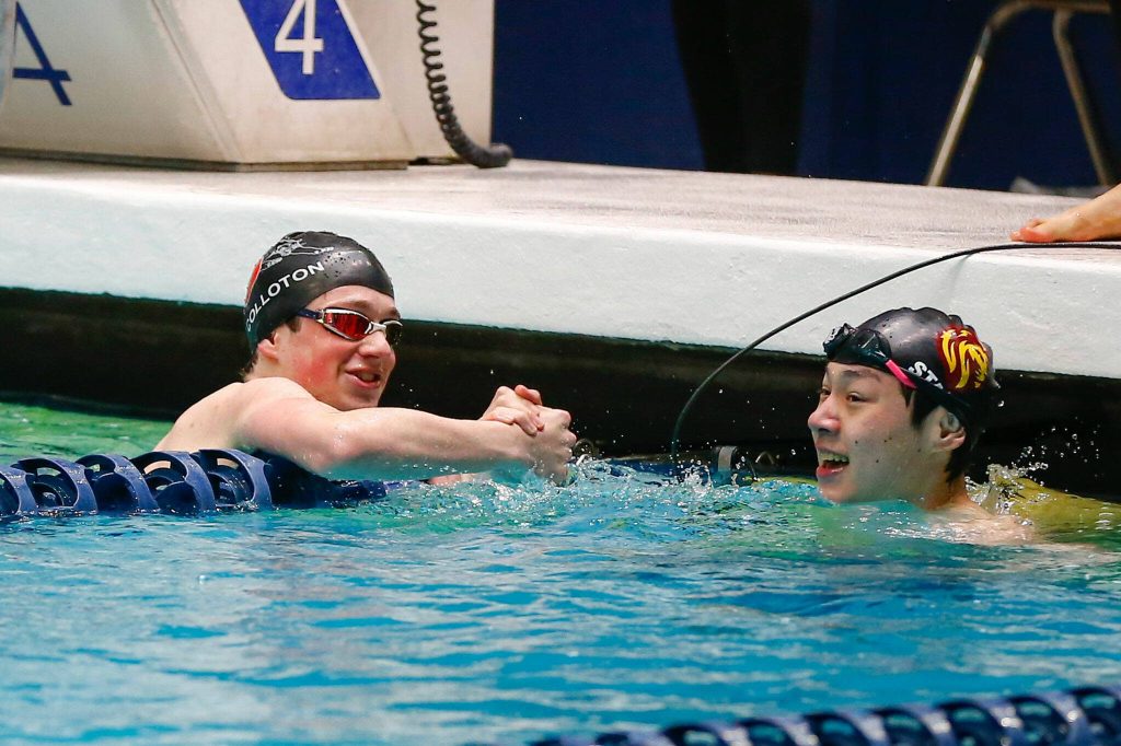 Snohomishs Connor Colloton congratulates a fellow swimmer after swimming in the 100 yard backstroke consolation race during the WIAA 3A Boys Swim and Dive Championships on Saturday, Feb. 17, 2024, at the Weyerhaeuser King County Aquatic Center in Federal Way, Washington. (Ryan Berry / The Herald)