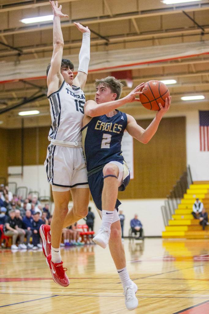 Mountlake Terraces Jaxon Dubiel leaps in the air to try and block Arlingtons Leyton Martins layup during the 3A boys district championship game on Saturday, Feb. 17, 2024 in Marysville, Washington. (Olivia Vanni / The Herald)