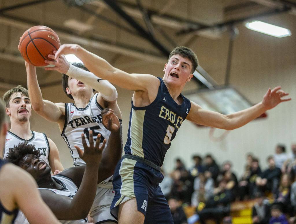 Arlingtons Jacoby Falor blocks a shot by Mountlake Terraces Jaxon Dubiel during the 3A boys district championship game on Saturday, Feb. 17, 2024 in Marysville, Washington. (Olivia Vanni / The Herald)