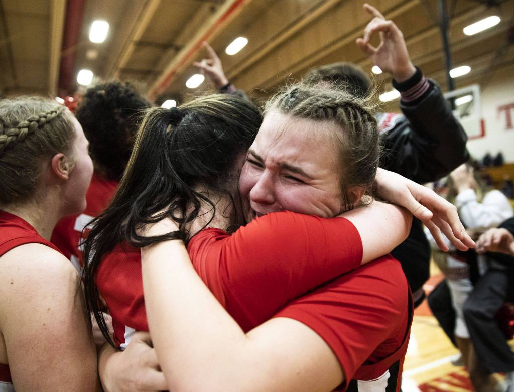 Snohomish players embrace after beating Arlington in the 3A girls district championship game on Saturday, Feb. 17, 2024 in Marysville, Washington. (Olivia Vanni / The Herald)