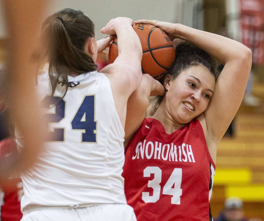Arlingtons Katie Snow tries to take the ball from Snohomishs Tyler Gildersleeve-Stiles during the 3A girls district championship game on Saturday, Feb. 17, 2024 in Marysville, Washington. (Olivia Vanni / The Herald)