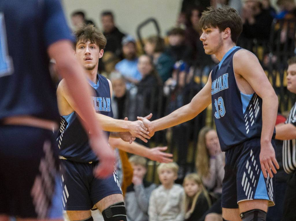 Toby Trichler, left, and brother Eli Trichler, right, high-five after a blocked shot during a game against Kings on Jan. 23 in Shoreline. (Olivia Vanni / The Herald)