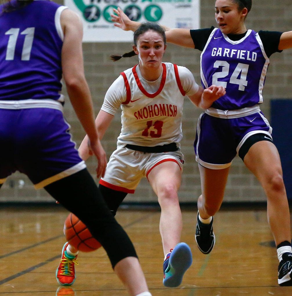 Snohomishs Sienna Capelli tries to make space between defenders against Garfield during a playoff matchup at Arlington High School on Friday, Feb. 23, 2024, in Arlington, Washington. (Ryan Berry / The Herald)