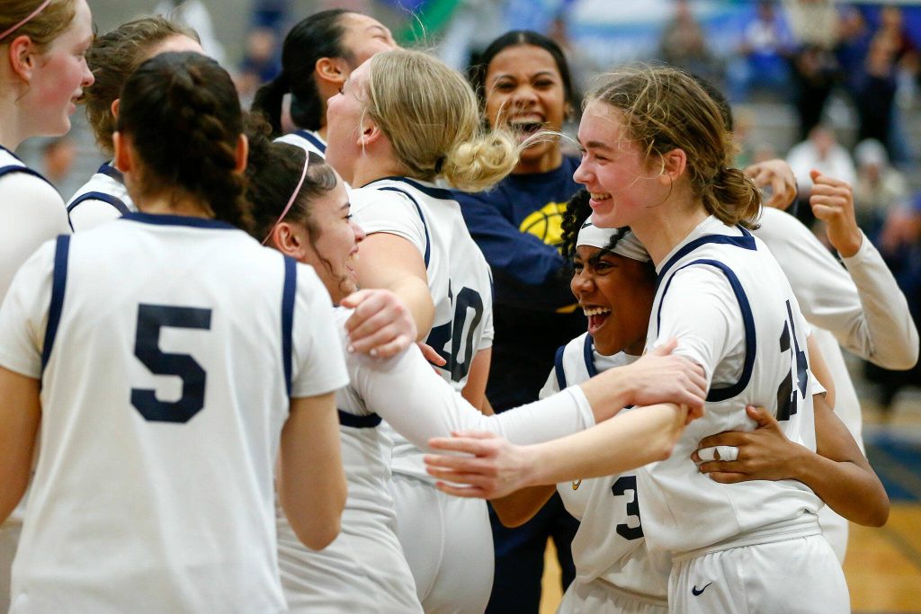 The Everett girls celebrate a playoff victory over Seattle Prep at Shorewood High School on Saturday, Feb. 24, 2024, in Shoreline, Washington. (Ryan Berry / The Herald)