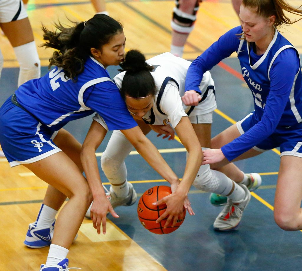 Everett senior Mae Washington gets tied up by two Seattle Prep defenders during a playoff matchup at Shorewood High School on Saturday, Feb. 24, 2024, in Shoreline, Washington. (Ryan Berry / The Herald)